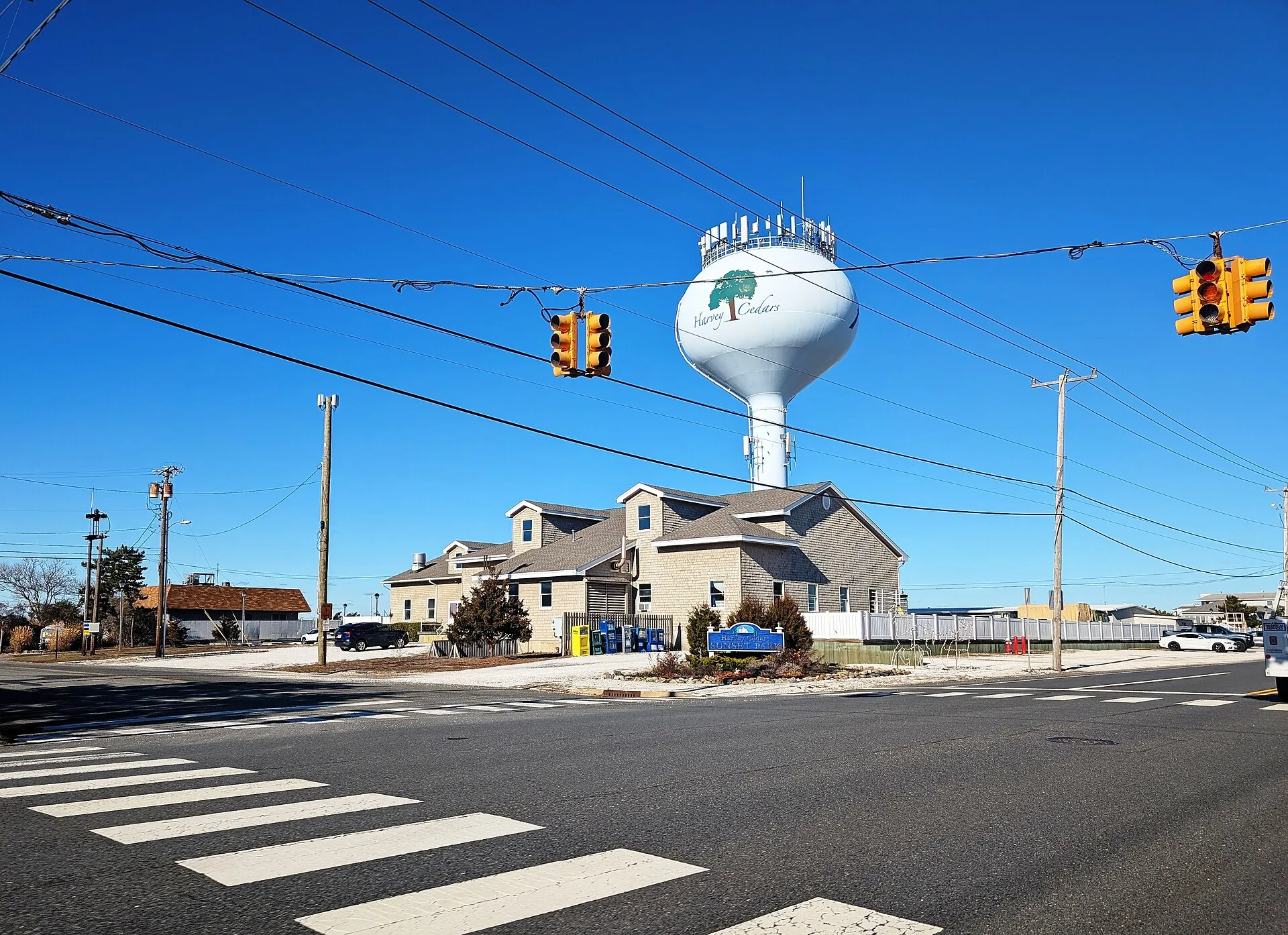 Photo of a sign for Sunset Park and the water tower in Harvey Cedars, New Jersey. Photo taken from County Route 607 (Long Beach Boulevard) at Salem Avenue looking north