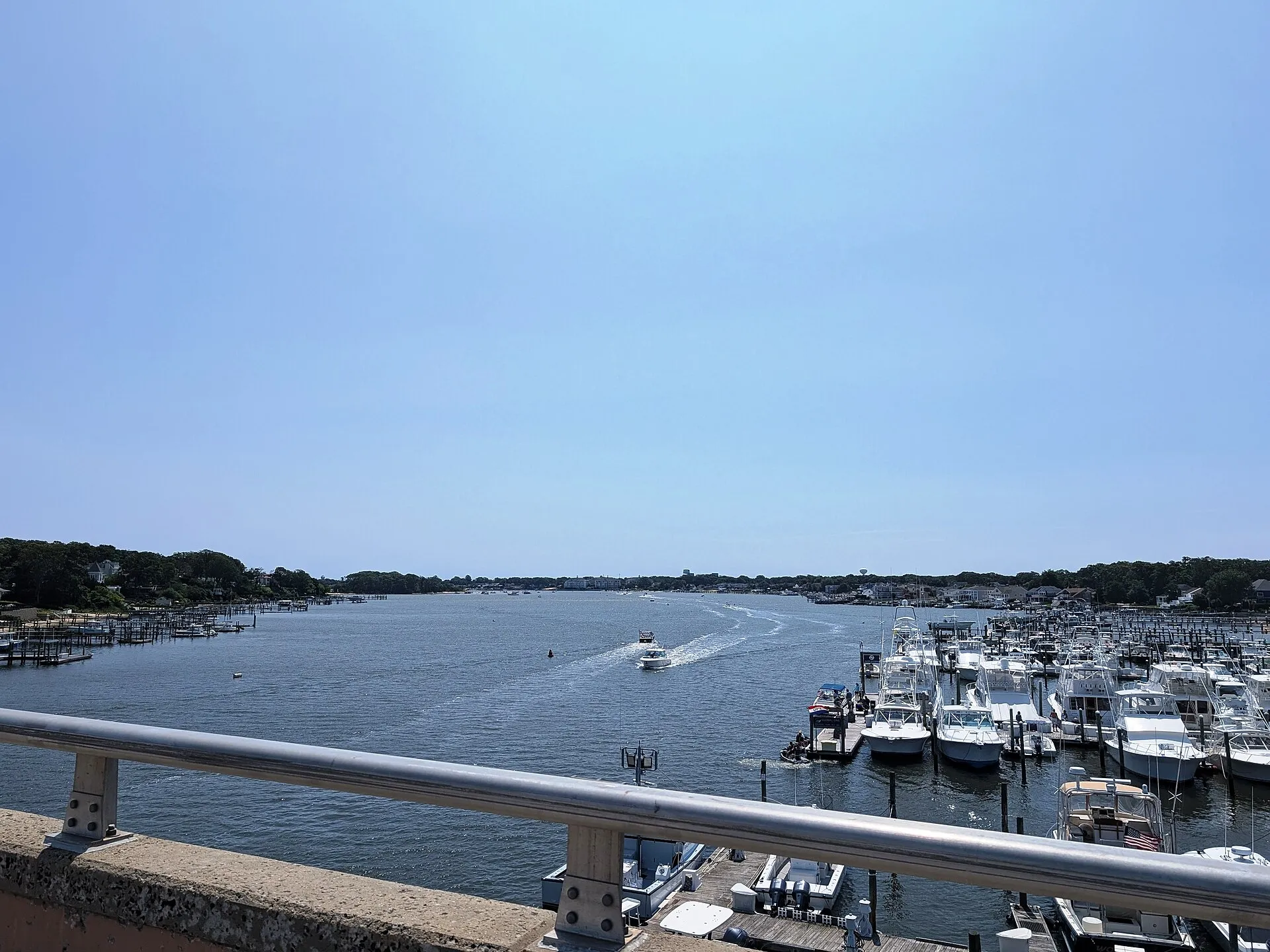 Photo of the Manasquan River looking downstream from the New Jersey Route 70 bridge over the river. Photo taken looking southeast. Brielle, Monmouth County is on the left (east) and Point Pleasant, Ocean County is on