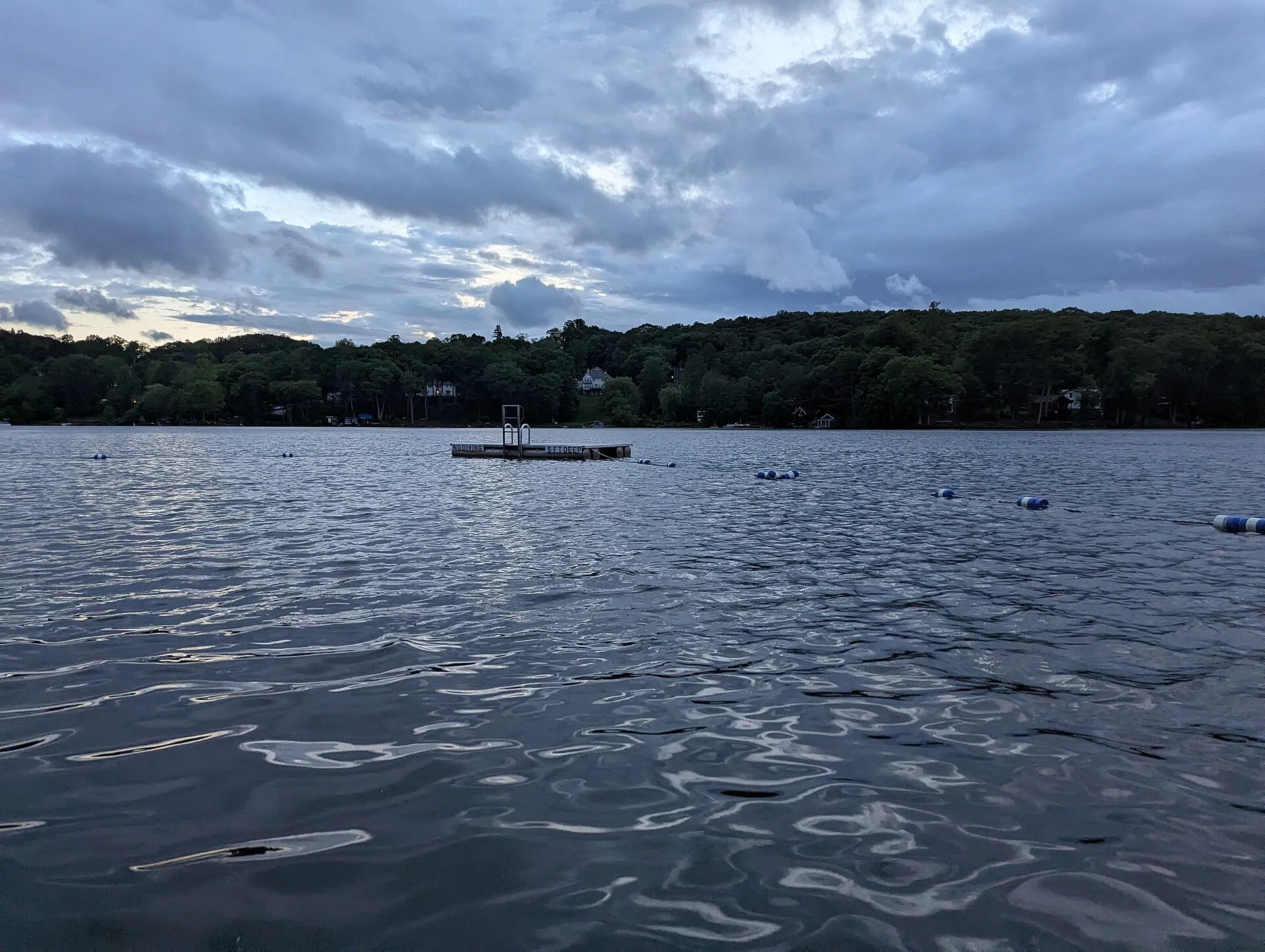 A floating dock and buoy lines in Lake Oscawana during the day