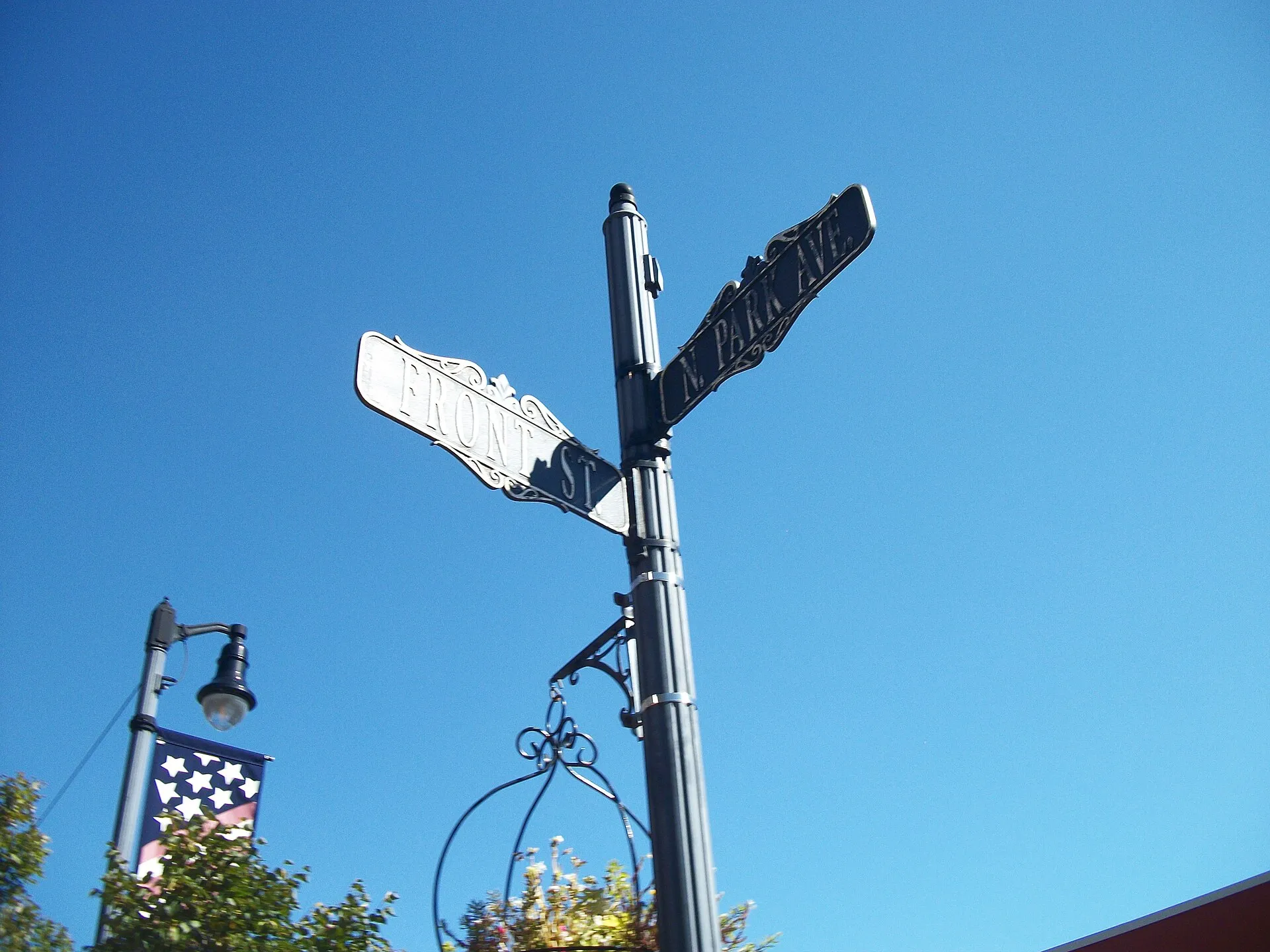 Antique-style street sign for Front Street and North Park Avenue on the north side of Rockville Centre (LIRR station), 2021
