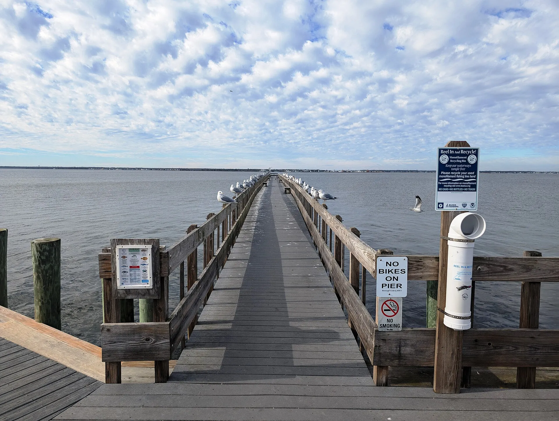 Photo of a fishing pier roughly following the alignment of an old Pennsylvania Railroad trestle over the Barnegat Bay destroyed in 1946 in Seaside Park, New Jersey. Photo taken looking west-northwest