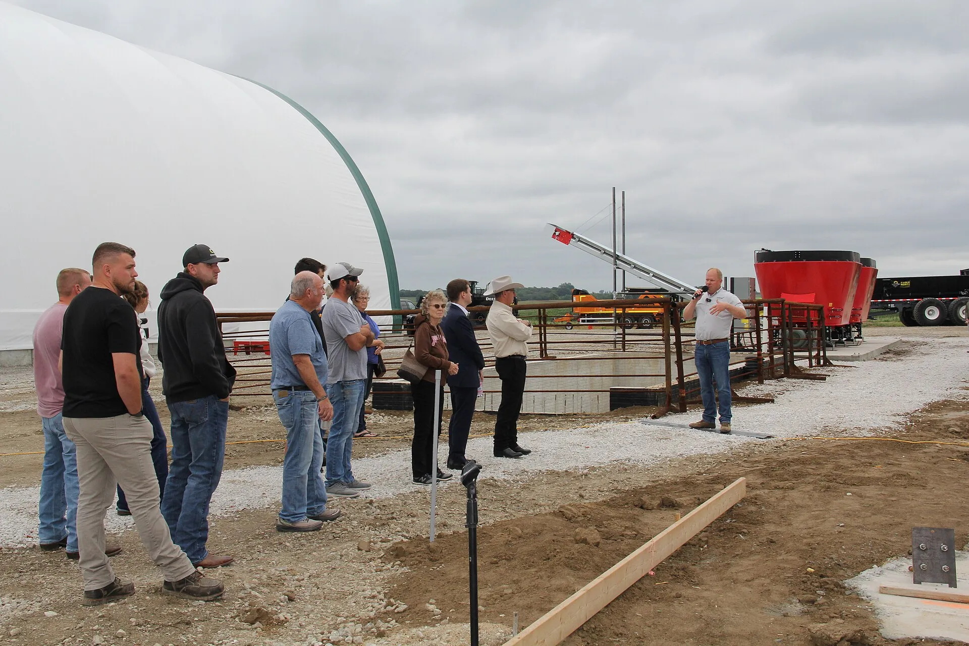 A small crowd gathers for a tour of a new fertilizer facility as owner Abe Sandquist speaks at the microphone. U.S. Department of Agriculture (USDA) Rural Development Iowa State Director Mike Sexton,