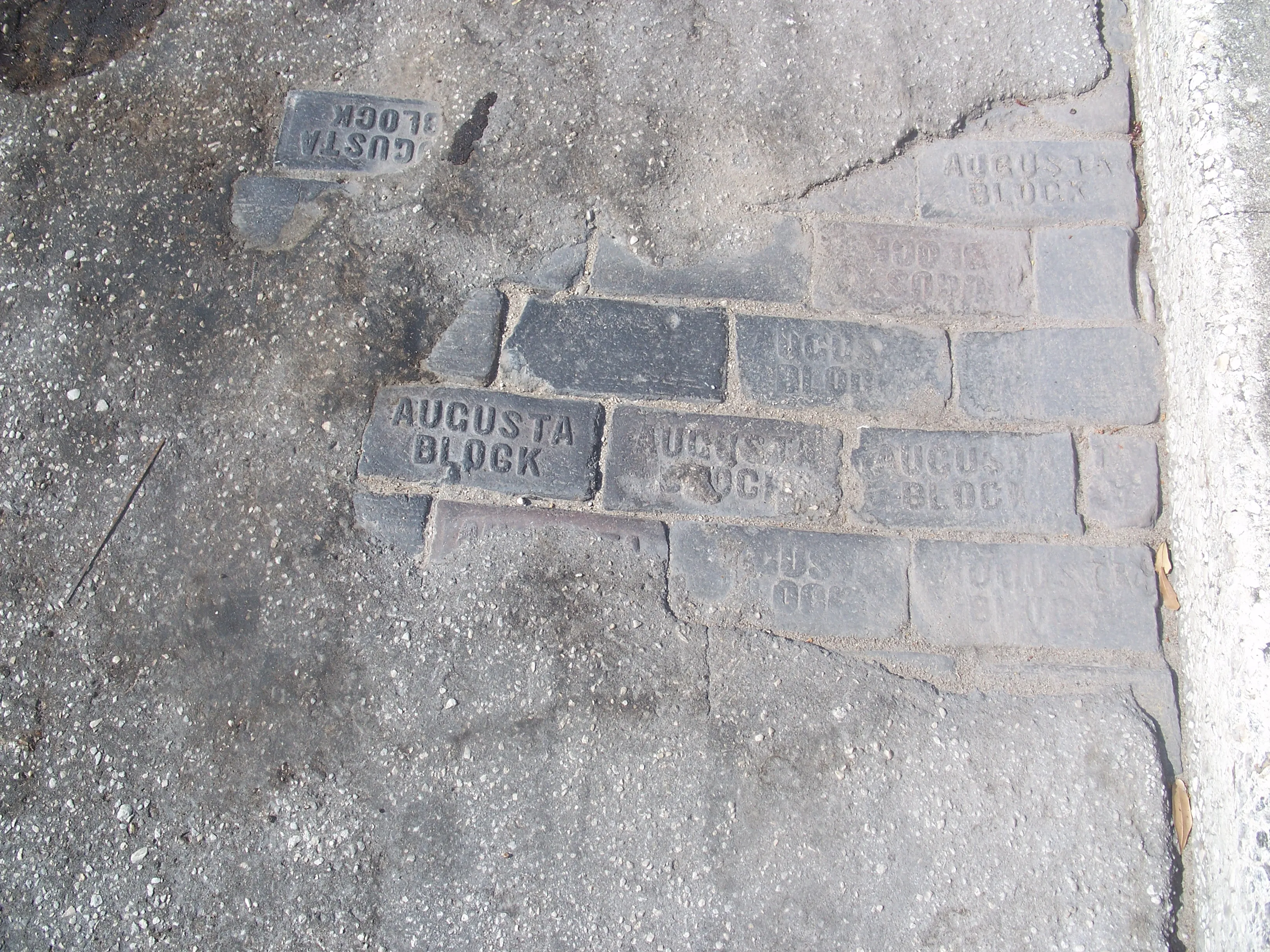 Old brick street showing through asphalt in St. Cloud