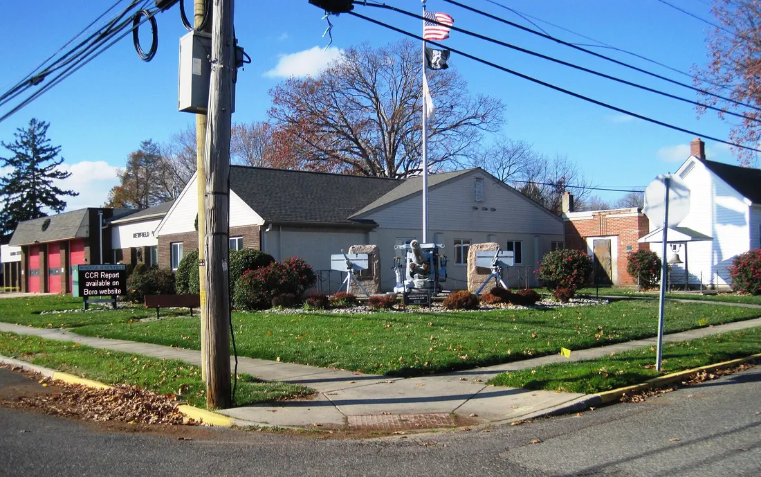 Photo of the Newfield, New Jersey municipal building. In the foreground is Newfield Veterans Memorial Park. Photo taken from County Route 661 (Catawba Avenue) at Church Street looking west-northwest.
