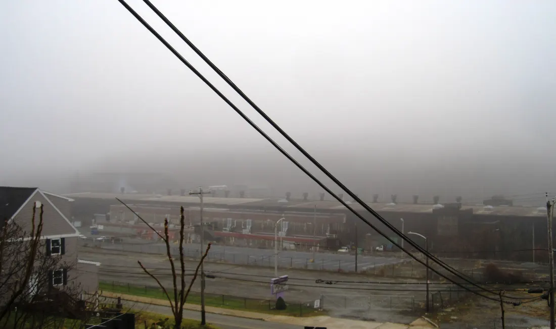Photo of a former steel mill, now used as a food pantry, in South Coatesville, Pennsylvania in foggy weather. Photo taken from Modena Road between 1st Avenue and Burton Alley looking west-southwest.