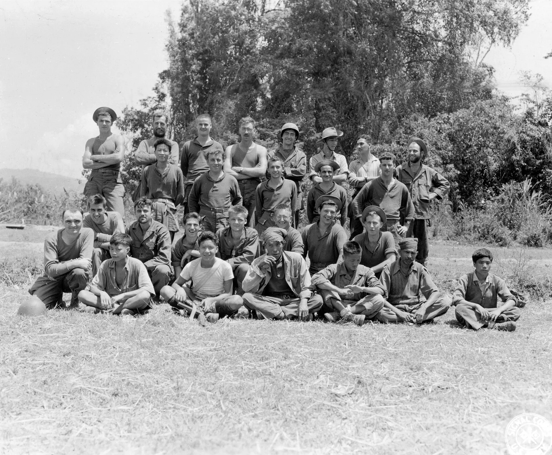 L to R, back row: Sgt. Harold R. Stevenson, Beaver, Pa. - Irish. Pfc. Stephen Komar, Minnesota. - Ukrainian. Pvt. George D. Altman, Adamsburg, Pa. - German. Sgt. Carl F. Hamelic, Cleveland, Ohio. - Dutch. Pvt. Hose L. Montoya, Las Vegas, Nevada. - Spanish. Capt. A. E. Quinn, Burma. - Anglo-Burmese. Capt. D. G. Wilson, Burma. - Anglo-Burmese. Pfc. Joseph Wuele, Italy. - Italian. Third row: Pvt. Kai
