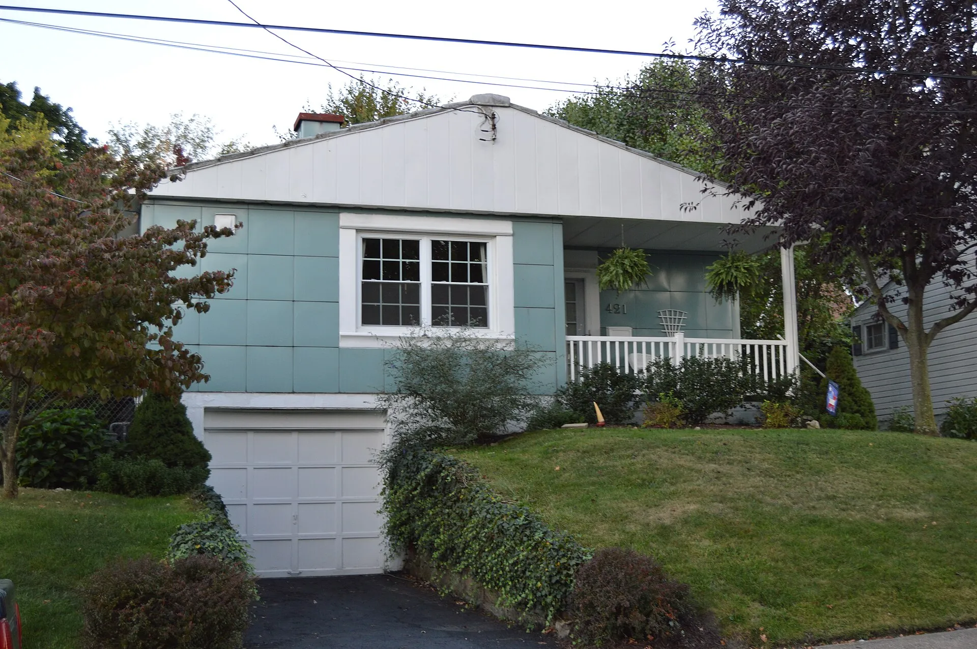 Front of the house located at 421 Fifth Street in California , Pennsylvania , United States . The upper story is a typical Lustron house , but its placement atop a basement garage is outstanding and exceptionally rare.