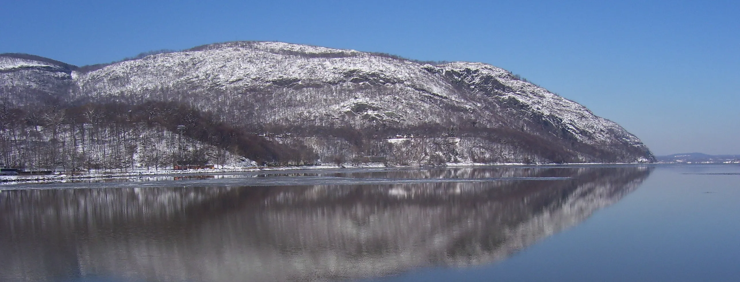 Crow's Nest Mountain in NY during winter reflecting on the Hudson River as seen from South Dock landing at the United States Military Academy