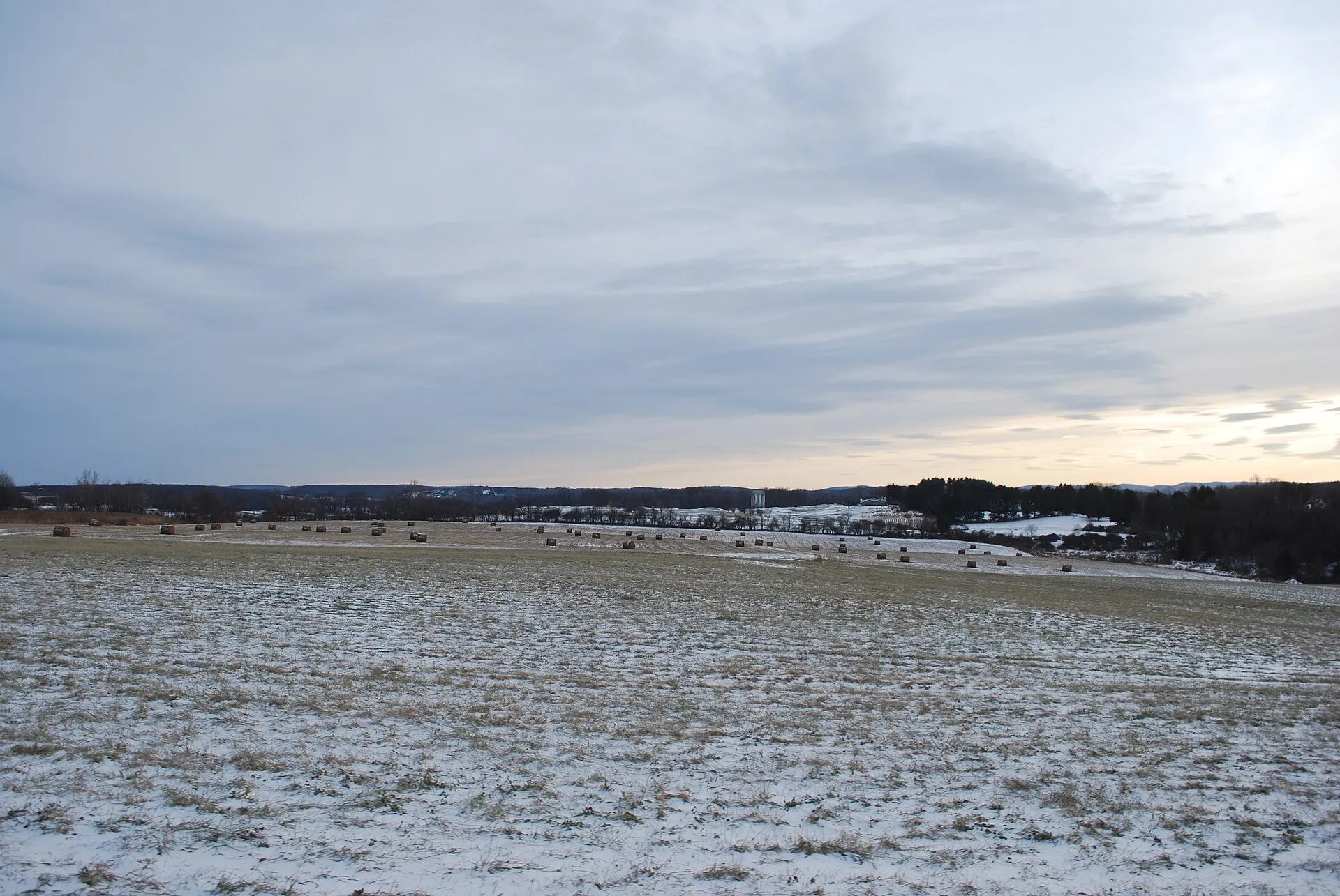 Bales of hay in an open field at dusk along County Route 89 in Lagrangeville, Dutchess County, New York