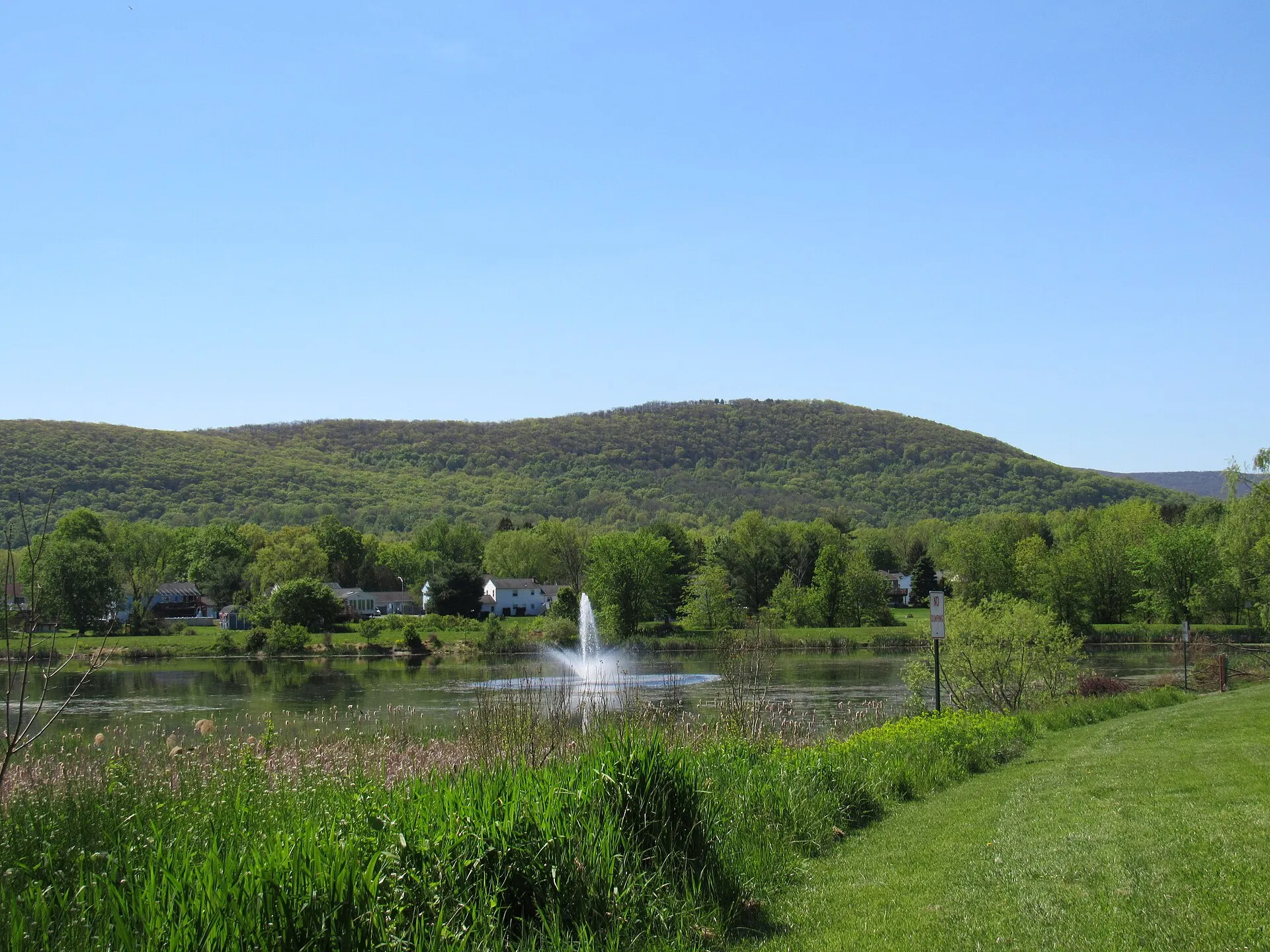 Village of Washingtonville unnamed Lake with a fountain. Woodcock Mountain is seen in the background