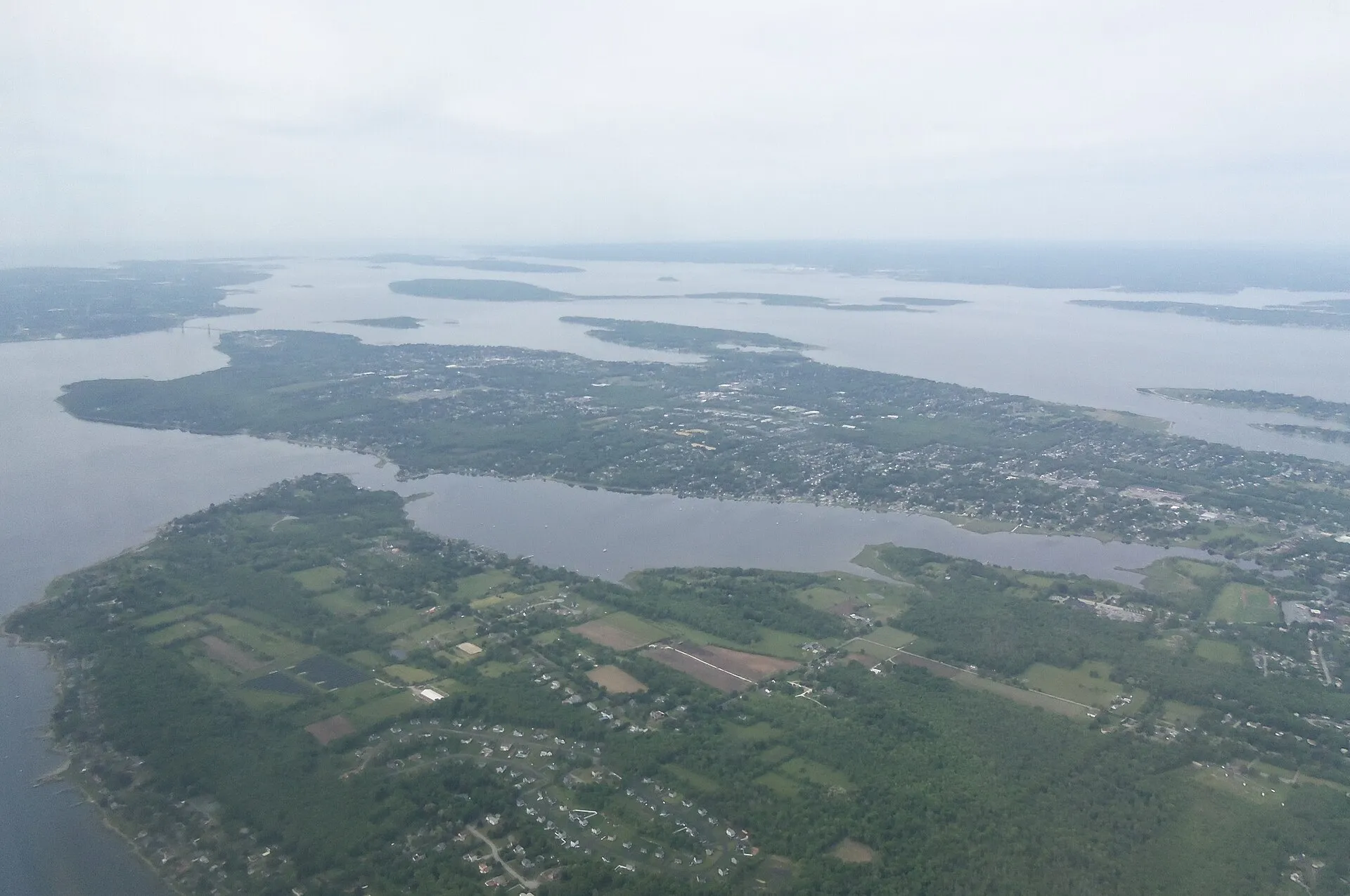 Oblique aerial view of Narragansett Bay, Rhode Island. Looking southwest. The town of Bristol is on the peninsula in the center. Kickemuit River Shellfish Management….