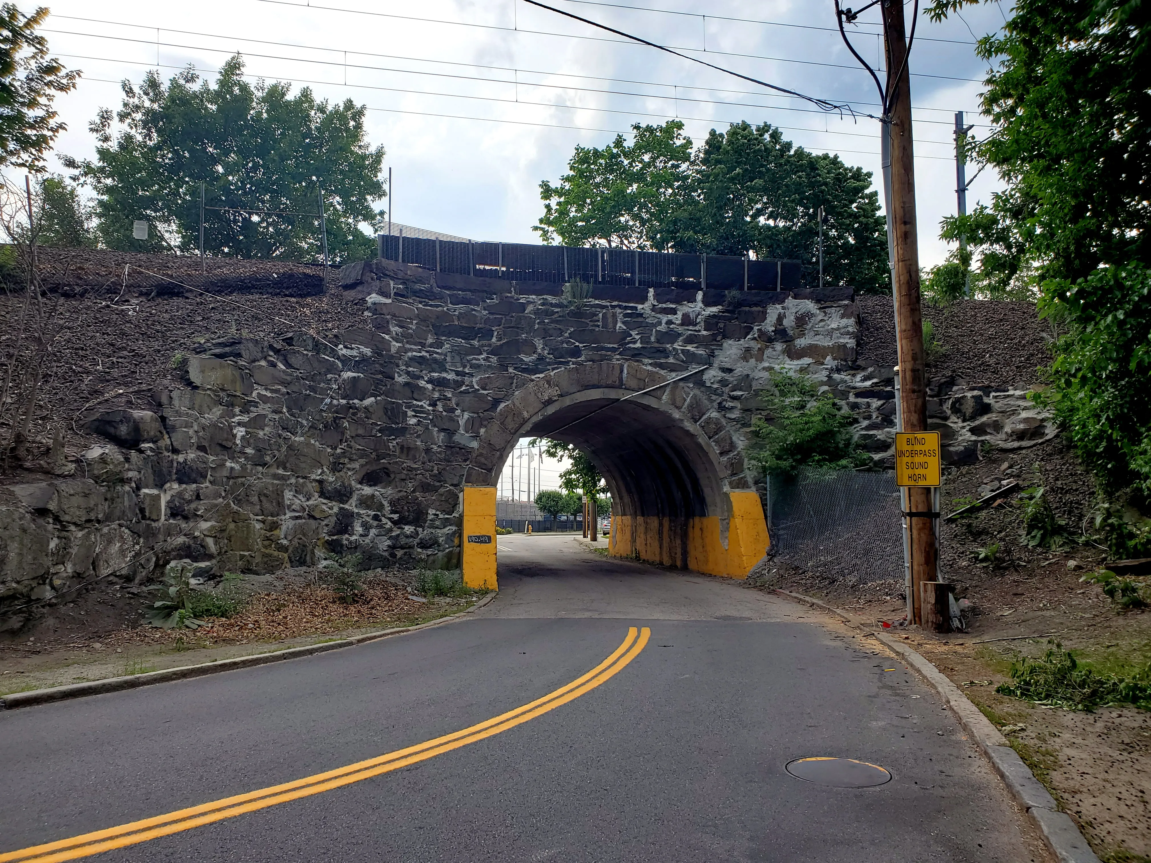 Stone arch bridge carrying the Northeast Corridor over High Street, Central Falls, June 2021.