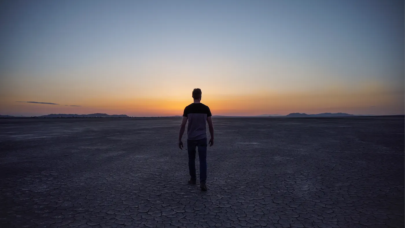 Figure crossing the desert at sunset in Adelanto