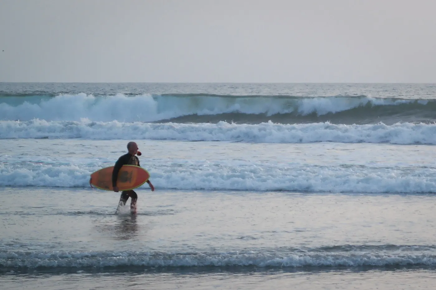 A surfer on the beach at Oceanside