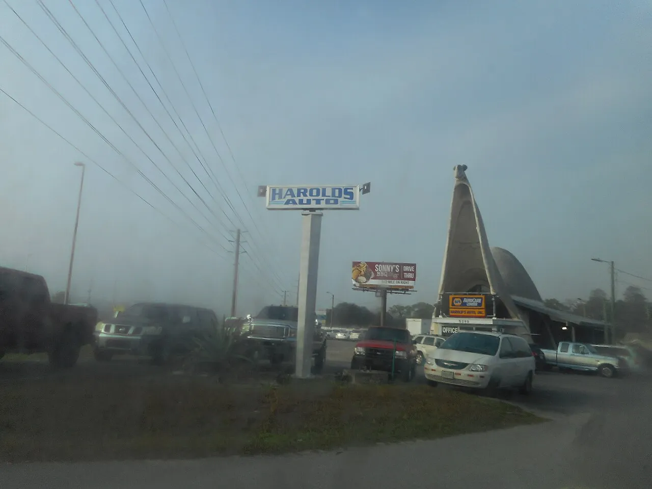 The third image of Harold's Garage, the former Sinclair Service Station shaped like a dinosaur on US 19 in Spring Hill, Florida, as seen from Balm Street in Spring Hill, Florida. I had a fourth picture, but it turned out blurry. Two pictures of the l.