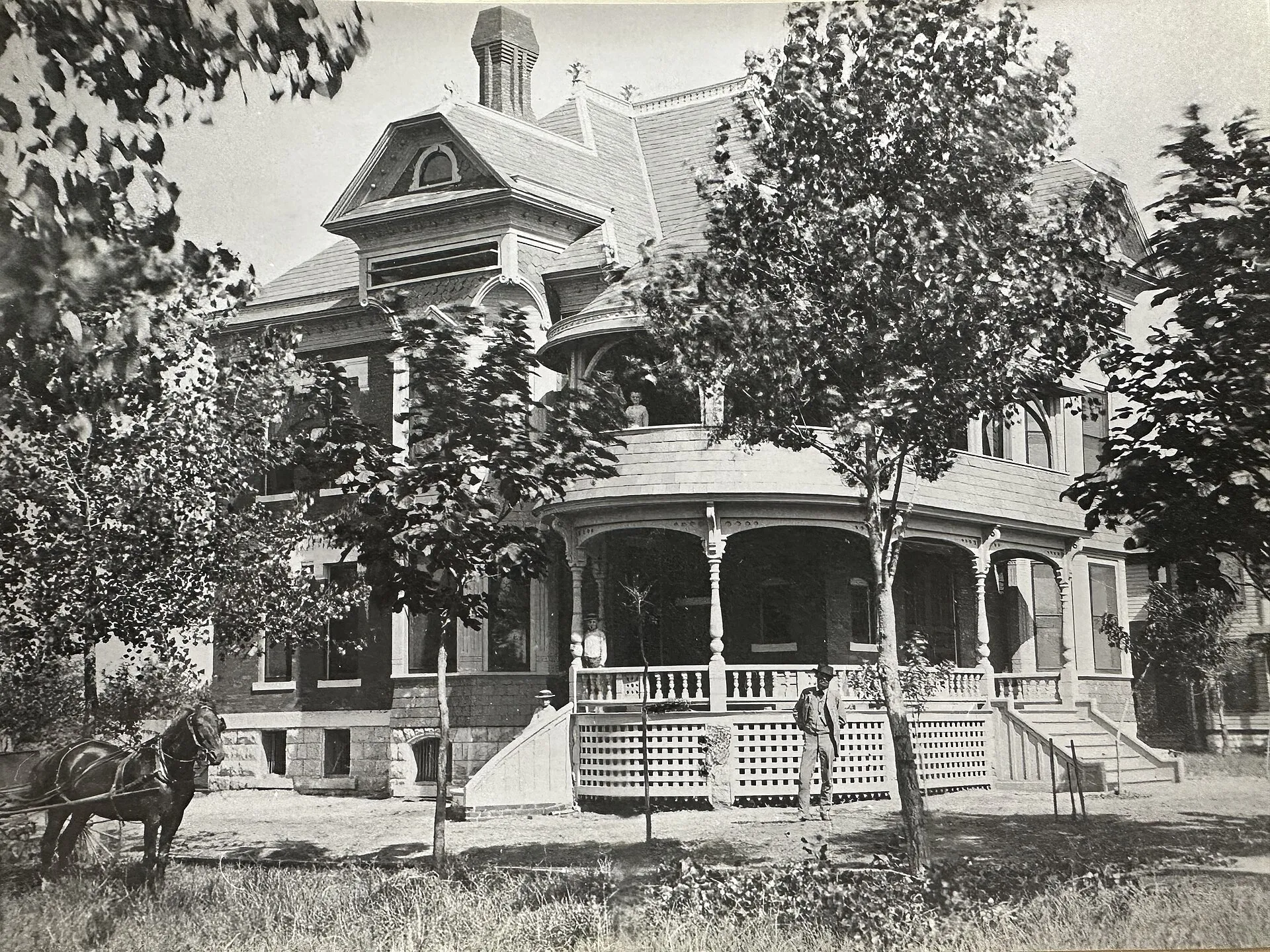 A photo of the southeast corner of the historic Amidon House in Wichita, Kansas taken upon its completion in 1887. The photo includes the home's original owners, Martin L. Garver and his wife Kathryn, as well as several of their children and the family's horse Colonel.